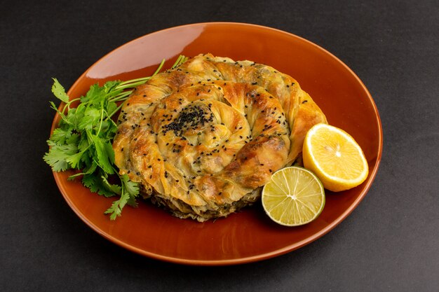 Front view pastry with meat delicious dough meal inside brown plate with lemon on the dark desk.