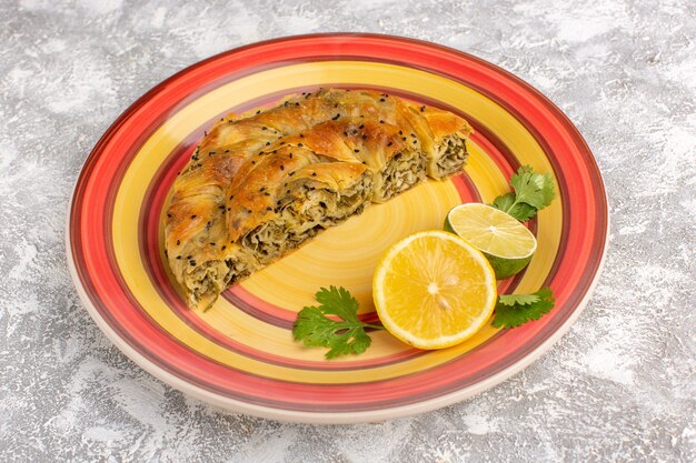 Front view pastry with meat delicious dough meal inside plate sliced with lemon on light-white desk.