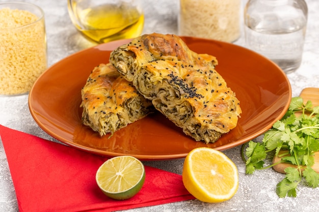 Front view pastry with meat delicious dough meal inside plate with lemon oil on white-light desk.