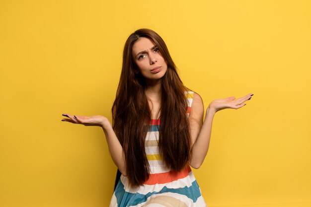 Front view of pensive adorable european woman. Stylish girl thinking and shruging