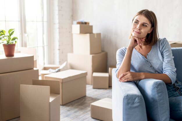 Front view of pensive woman on the couch ready to move out