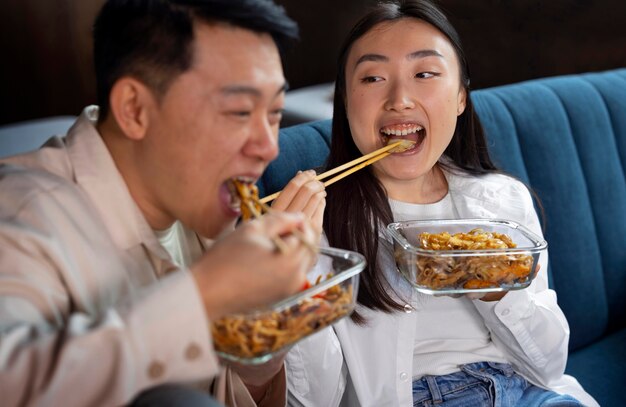 Вид спереди люди едят азиатскую еду