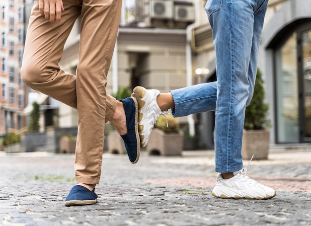 Persone in vista frontale che salutano in modo nuovo e normale con i piedi