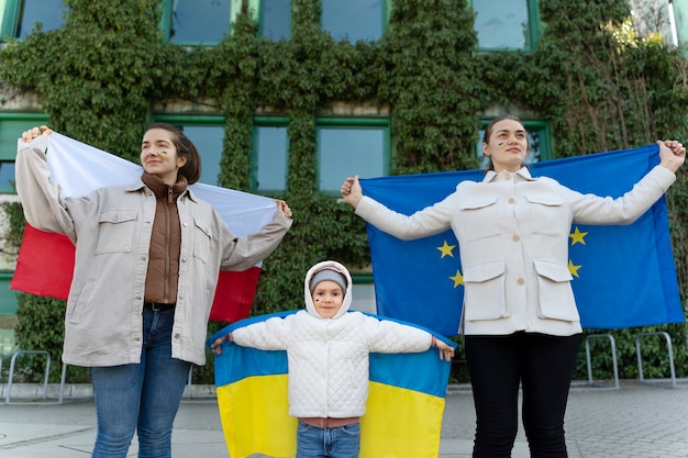 Foto gratuita persone di vista frontale che tengono bandiere