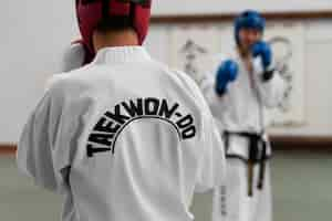 Free photo front view people practicing taekwondo