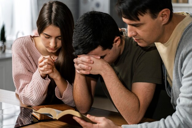 Front view of people praying together in the kitchen