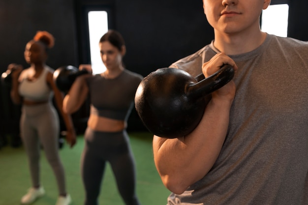 Free photo front view people training together at gym