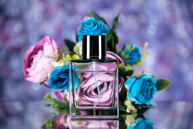 Флакон духов, вид спереди, цветные цветы на фиолетовом размытом фоне