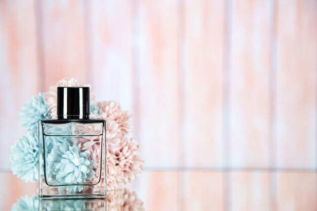 Front view perfume bottle flowers on beige blurred background free space