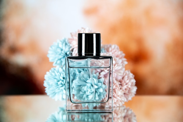 Front view of perfume bottle flowers on beige brown blurred background free space