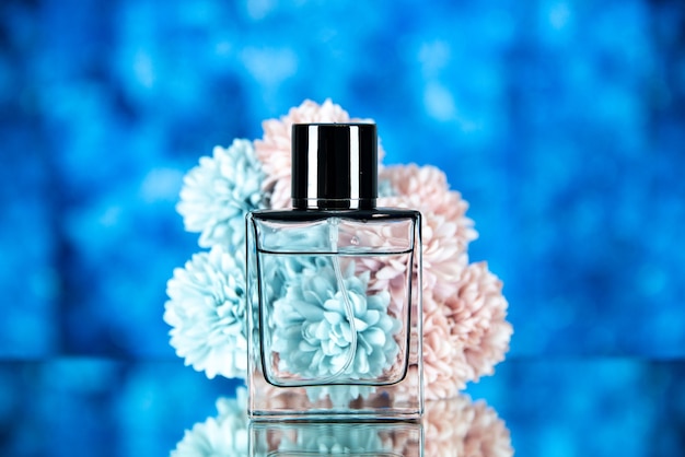 青いぼやけた背景に香水瓶の花の正面図