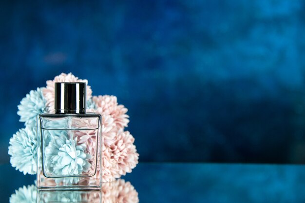 Front view perfume bottle flowers on dark blue background with free place