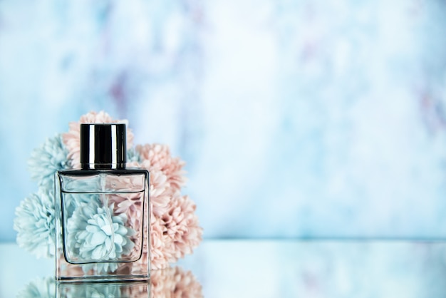 Front view perfume bottle flowers on light blue background free space