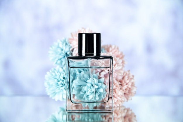 Front view of perfume bottle flowers on light blurred background free space