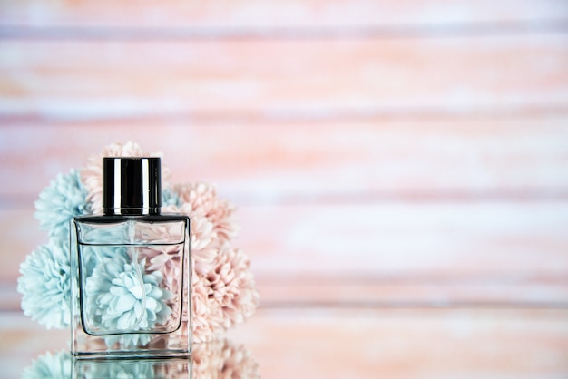 Foto gratuita fiori della bottiglia di profumo di vista frontale sullo spazio libero del fondo vago leggero