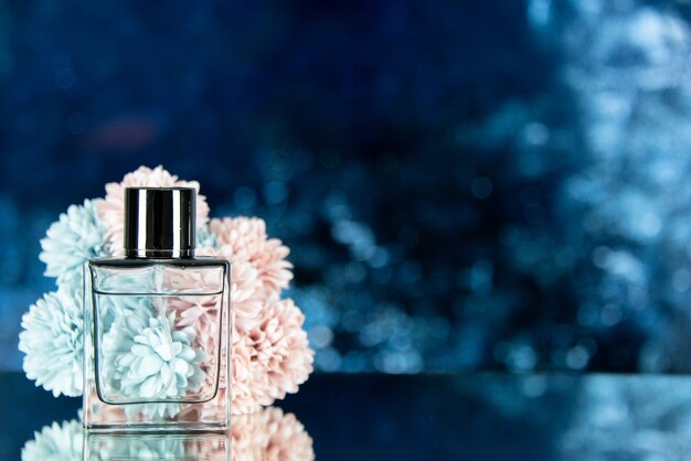 Front view perfume bottle flowers on ocean blue blurred background free space