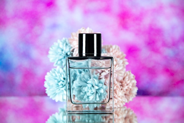 Front view of perfume bottle flowers on pink blurred background free space