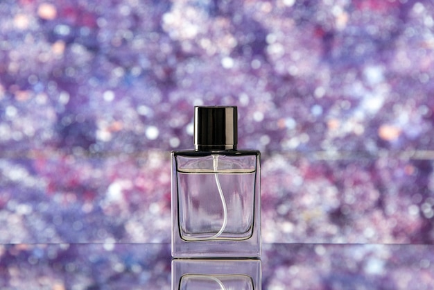 Бесплатное фото Флакон духов вид спереди на фиолетовом размытом фоне