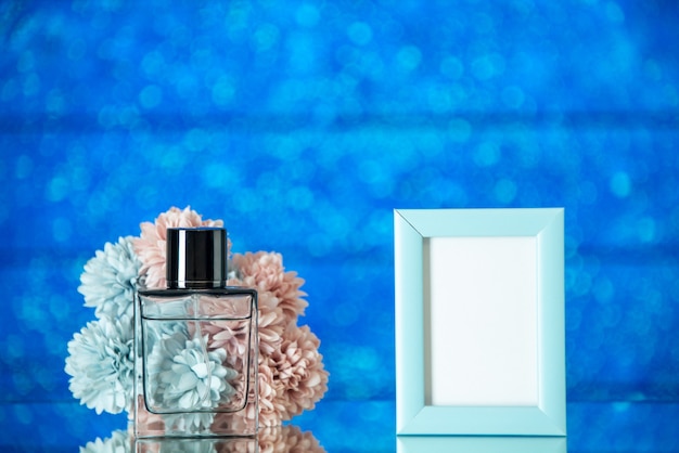 Front view perfume bottle small blue picture frame flowers on blue background