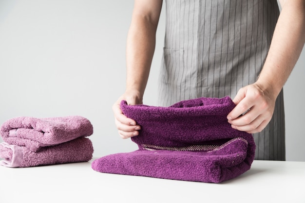 Front view person folding towels