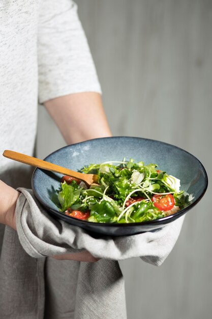 Front view of person holding a bowl of salad