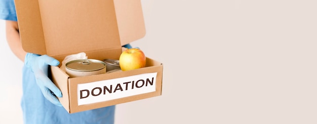 Вид спереди лица, занимающего коробку пожертвования пищи с копией пространства