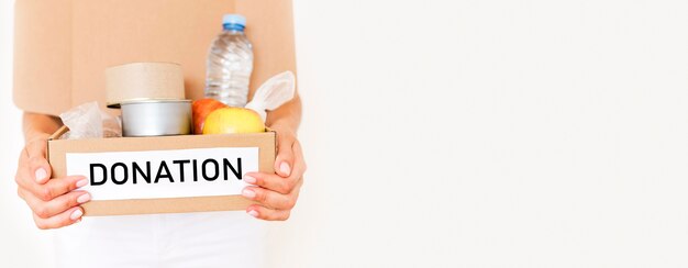 Front view of person holding box of food donation