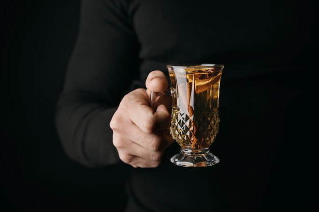 Front view person holding glass with winter drink