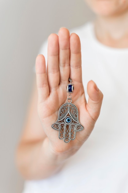 Front view of person holding hamsa pendant in hand