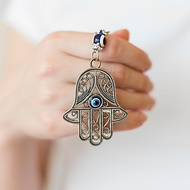 Front view of person holding hamsa pendant