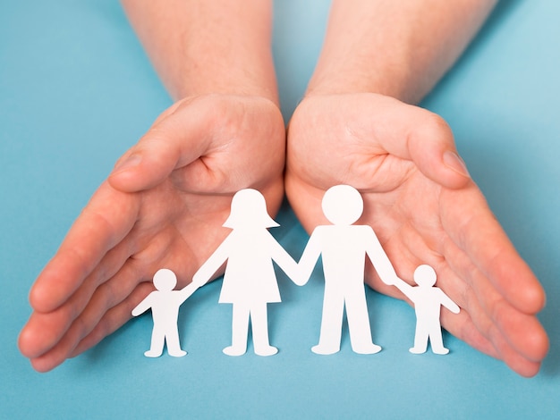 Front view person holding in hands cute paper family