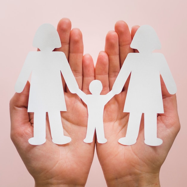 Front view person holding in hands cute paper lgbt family