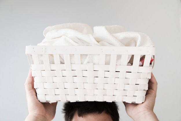 Front view person holding laundry basket on head