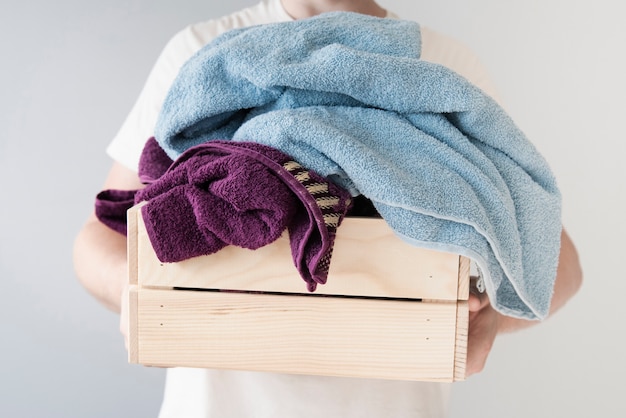 Front view person holding laundry box