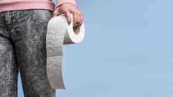 Free photo front view of person holding toilet paper roll with copy space