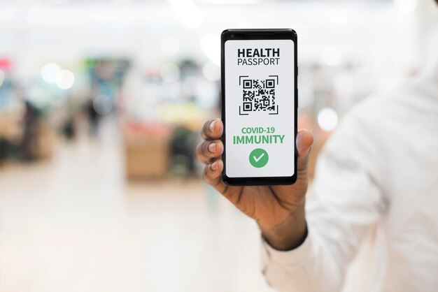 Вид спереди человека, держащего паспорт виртуального здоровья на смартфоне