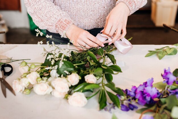 Front view person preparing bunch of flowers