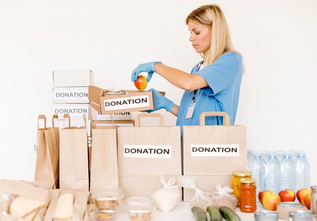 Front view of person preparing food bags for donation