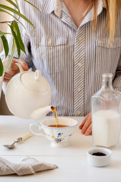 Foto gratuita vista frontale della persona che prepara il tè al latte