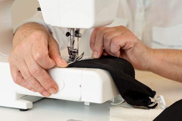 Front view of person using sewing machine for face mask