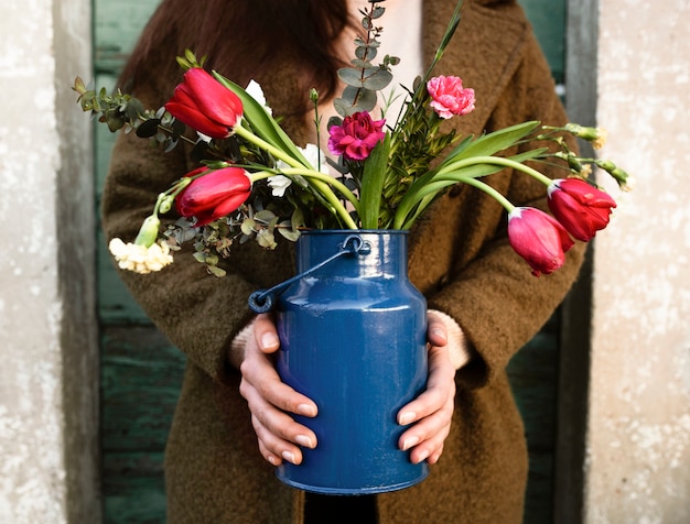 Вид спереди человека с вазой цветов