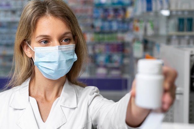 Free photo front view pharmacist wearing face mask