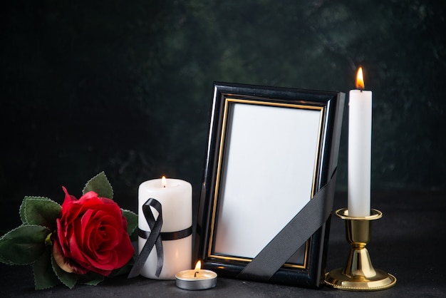 Front view of picture frame with burning candles on dark