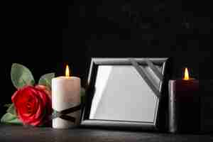 Free photo front view of picture frame with candle and flower on dark