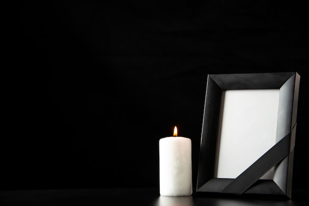 Front view of picture frame with white candle on the black