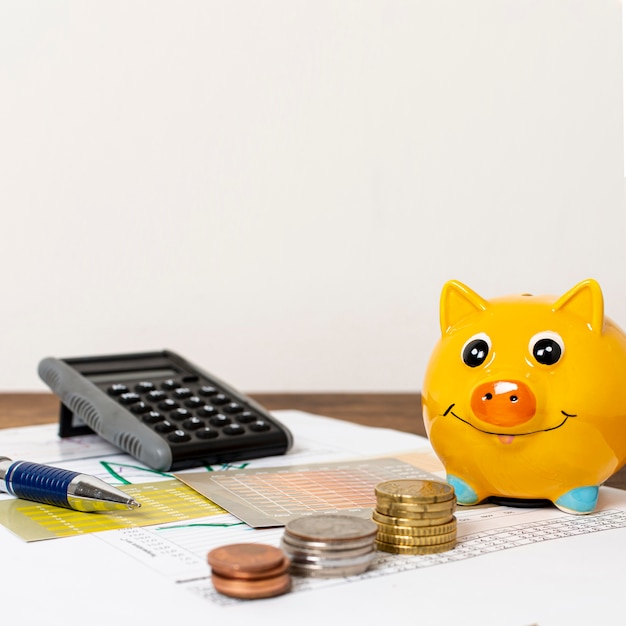 Free photo front view of piggy bank and piles of coins