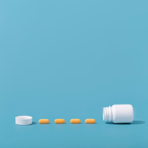 Front view of pills in row with container and copy space