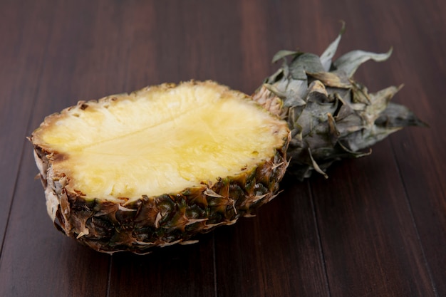 Free photo front view of pineapple half on wooden surface