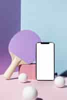 Free photo front view of ping pong balls and paddle with smartphone