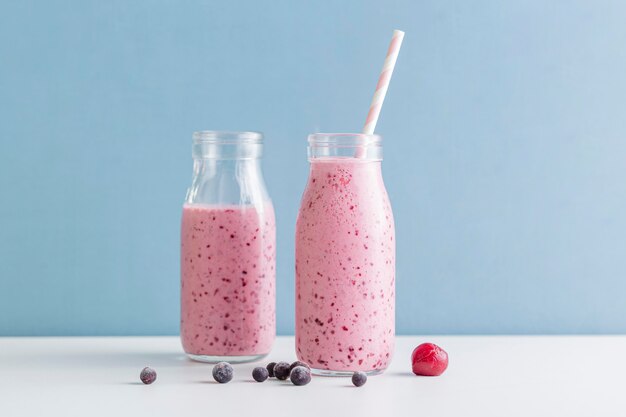 Front view pink smoothie bottles with blueberries